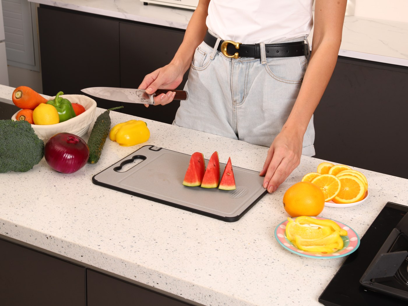 A TIBO cutting board on a kitchen counter with sliced fruit and vegetables