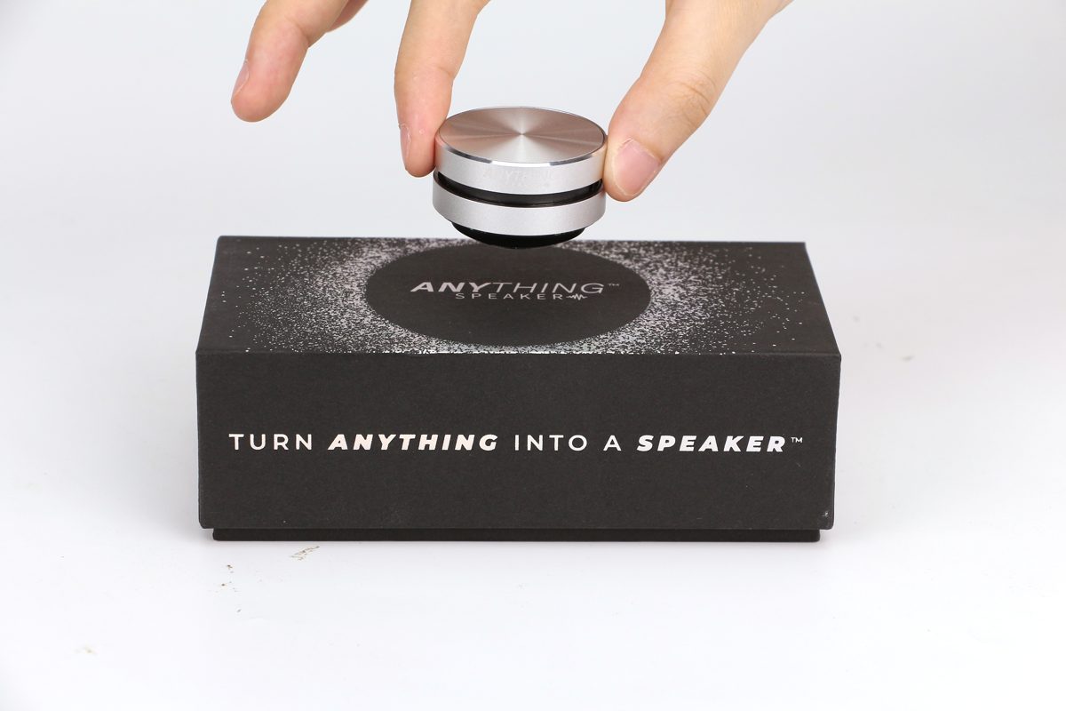 A small round Anything Speaker attached to the side of a guitar