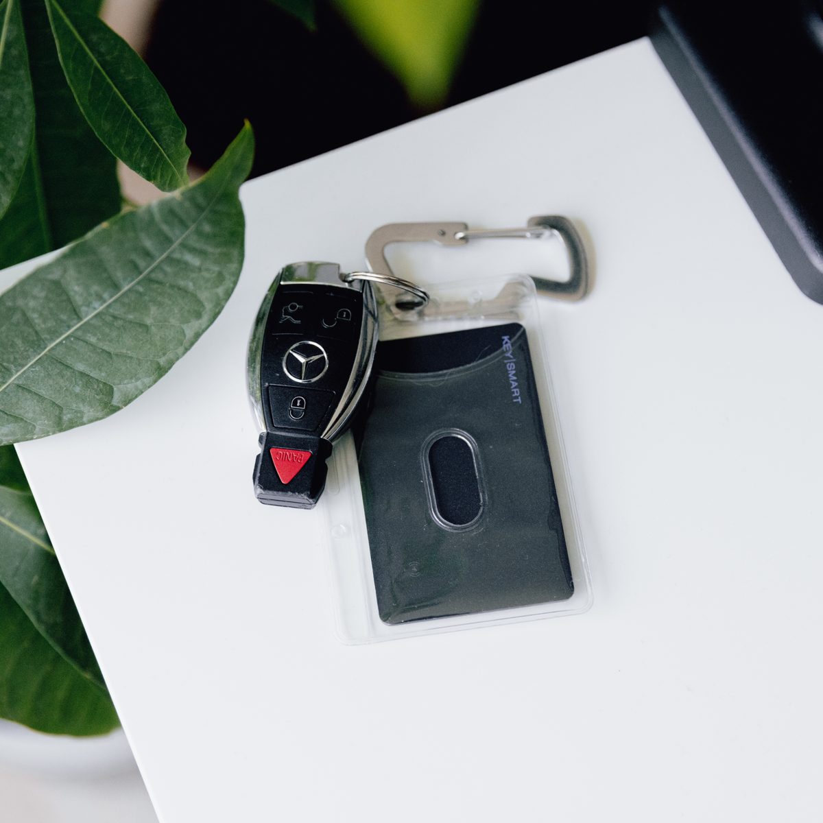 The slim KeySmart SmartCard tracker sliding into a leather wallet