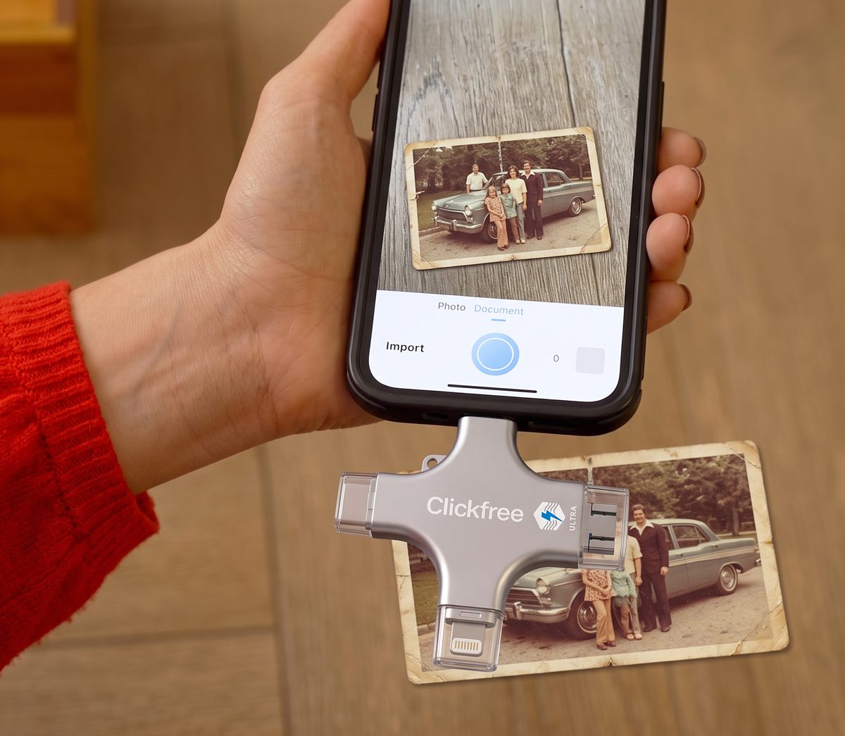 Old printed photographs being scanned with a phone next to a Clickfree device