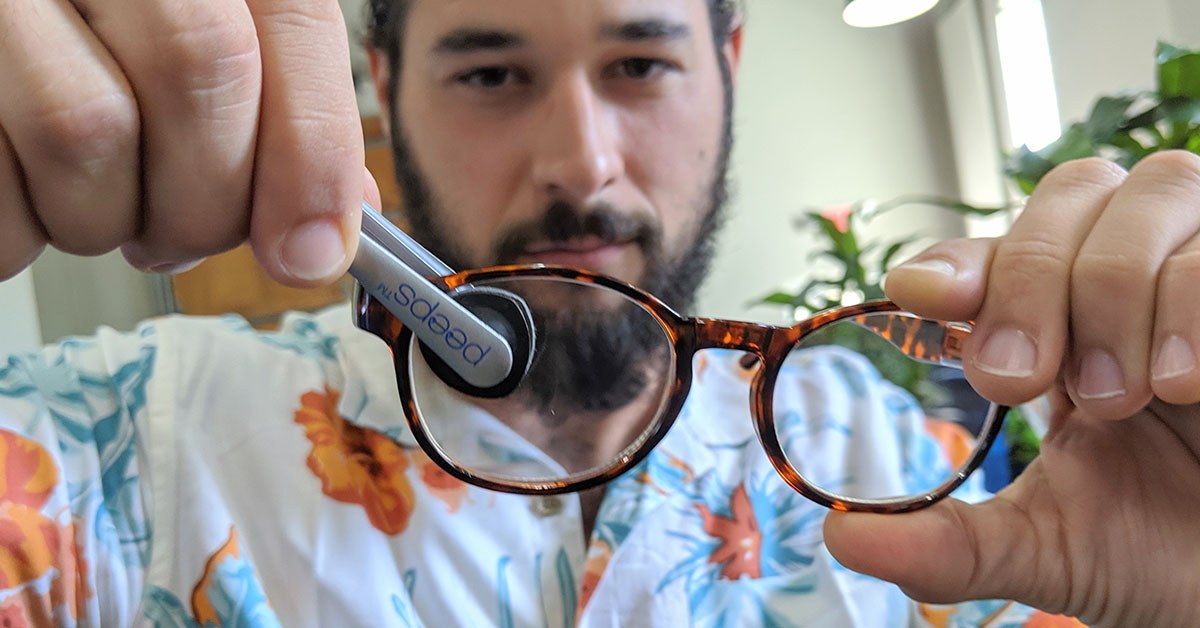 A close-up of Peeps cleaning pads pressed against an eyeglass lens