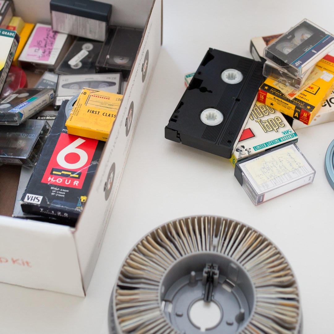 A box of old home movies, tapes and slides ready for digitizing